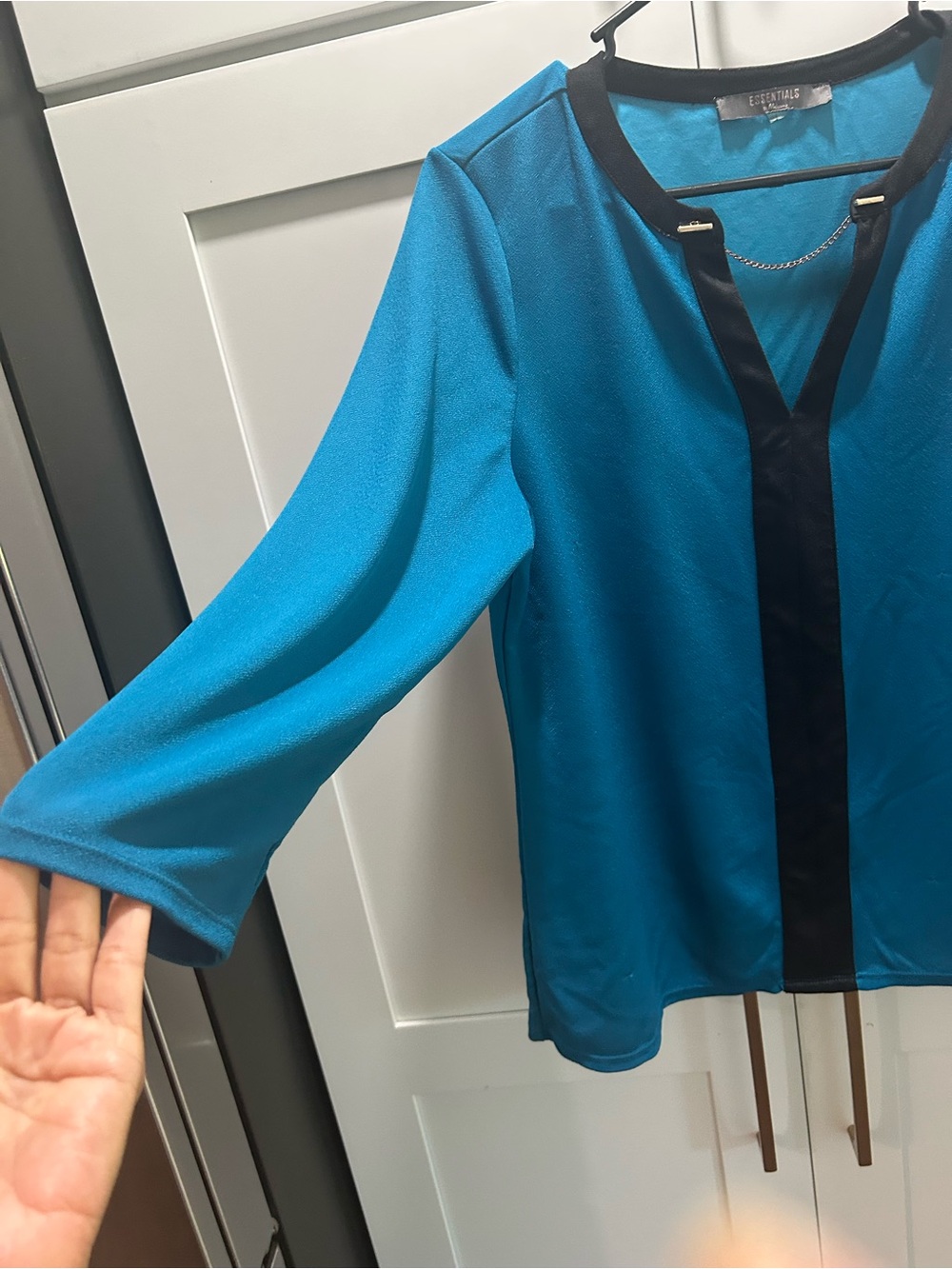 Essentials Women's Teal Blue V-Neck Blouse with Black Trim and Chain